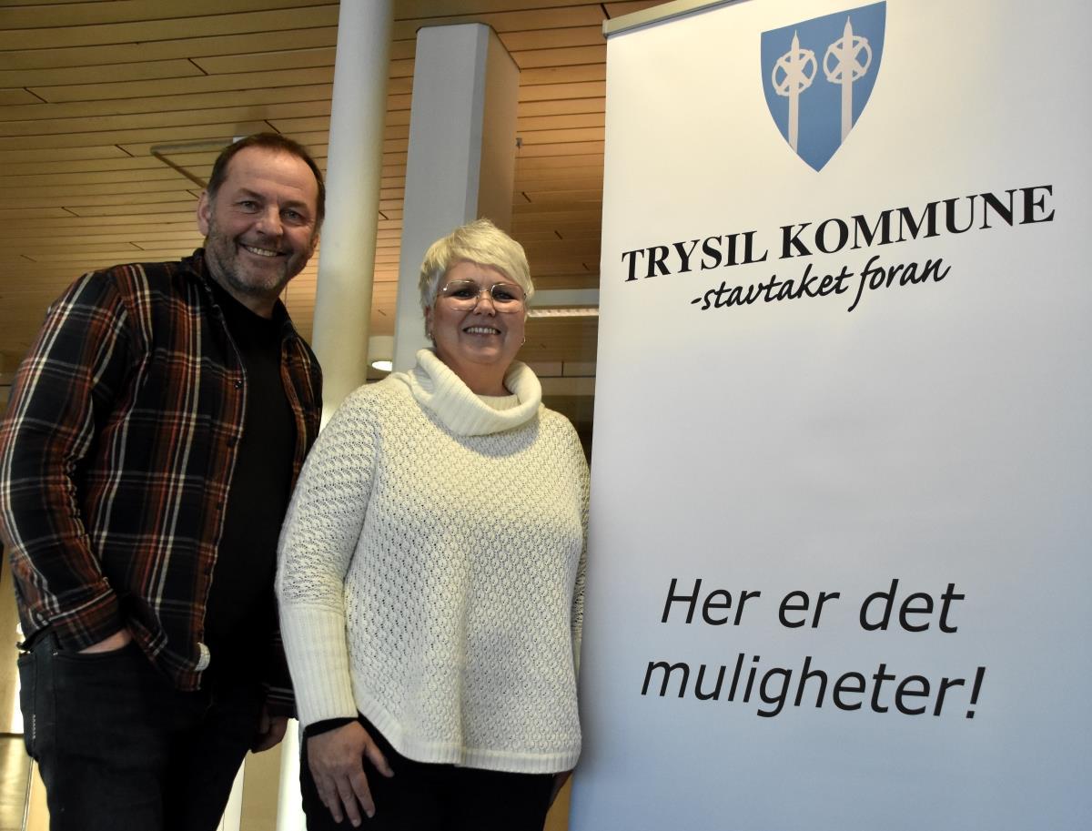 Harald Nyberg og Bente Hagen foran plakat med teksten Trysil kommune - stavtaket foran - Her er det muligheter - Klikk for stort bilde