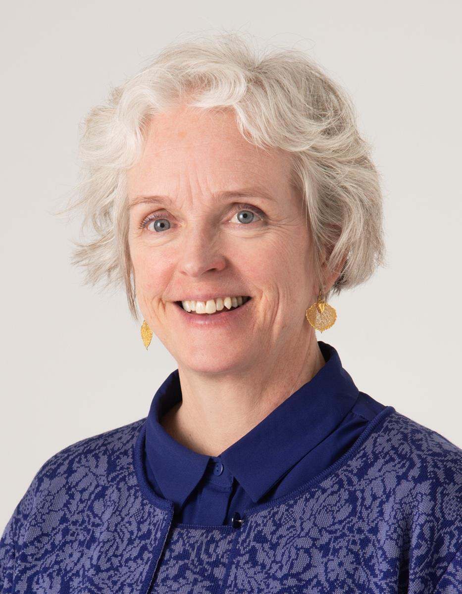 Portrett av en dame med lyst, kort hår og blåe klær. - Klikk for stort bilde