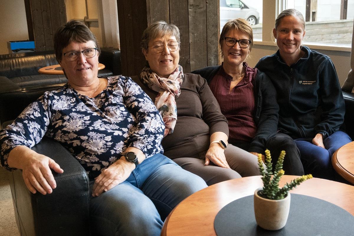 Fire kvinner som sitter i en sofa og smiler til kameraet - Klikk for stort bilde