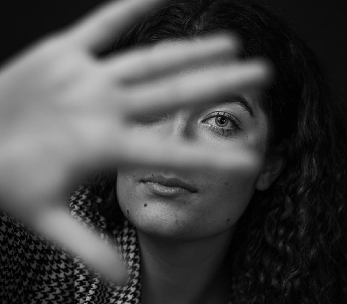 Kvinne holder en hånd foran ansiktet - Klikk for stort bilde