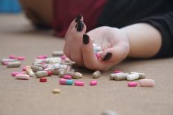 Kvinnehånd med tabletter i og rundt