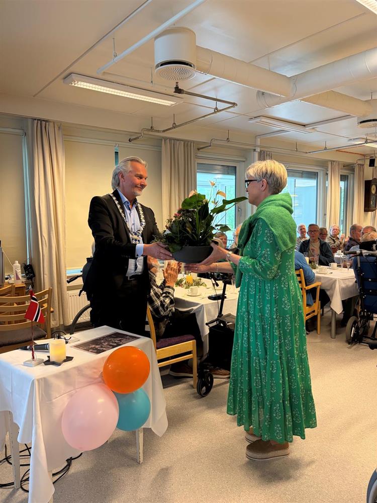 mann overrekker blomsteroppsats til dame - Klikk for stort bilde