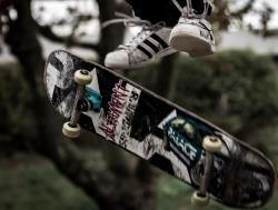 Skateboard i lufta med skaterens føtter over.
