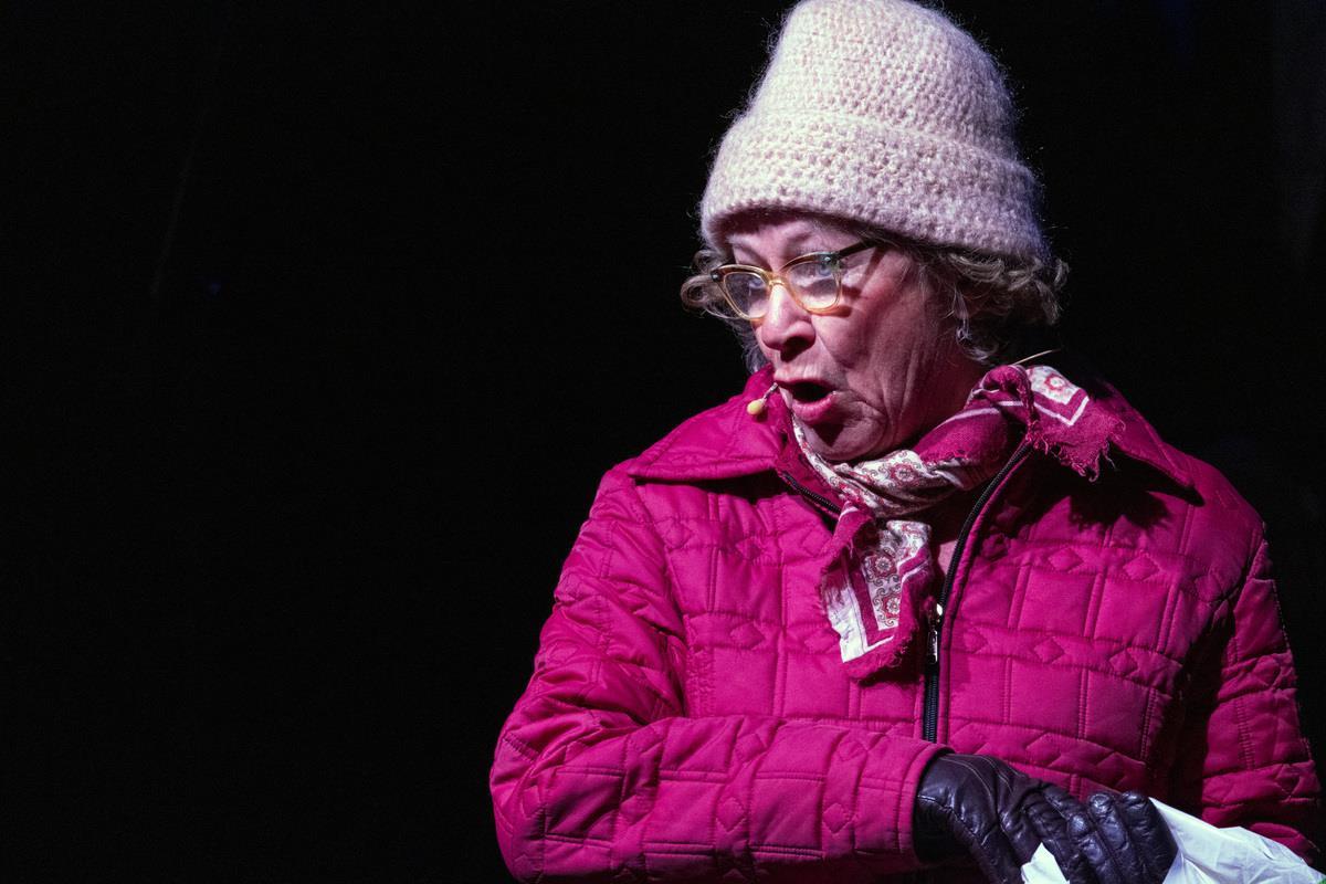 Ei dame som prater med lue, hansker og utejakke på. - Klikk for stort bilde