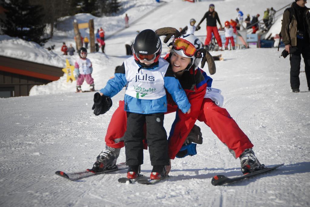 Skiskolelærer hjelper småtass på alpinski - Klikk for stort bilde