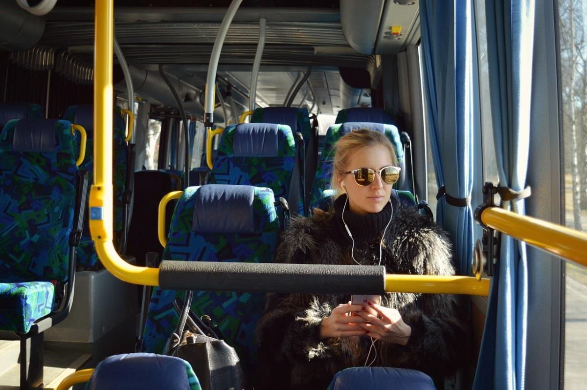 En ung kvinne sitter på en buss - Klikk for stort bilde