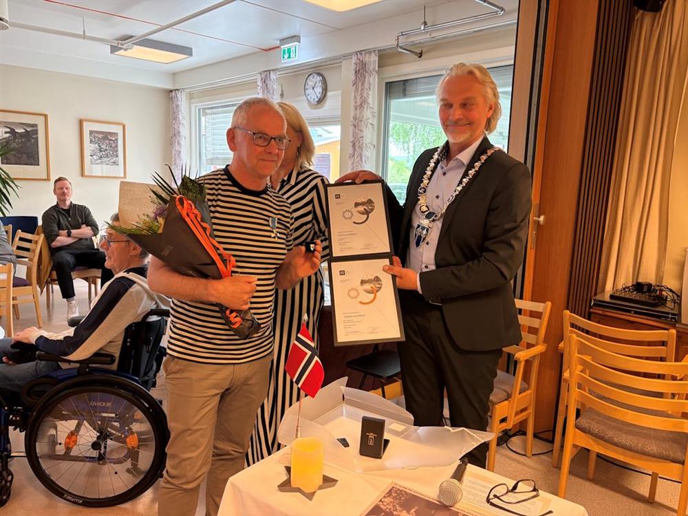 mann mottar medalje og hedersbevis - Klikk for stort bilde