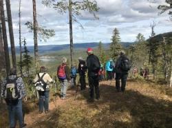 11 personer på skogstur med utsikt til vann