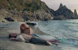 Havfrue ligger ved bevisstløs mann på strand