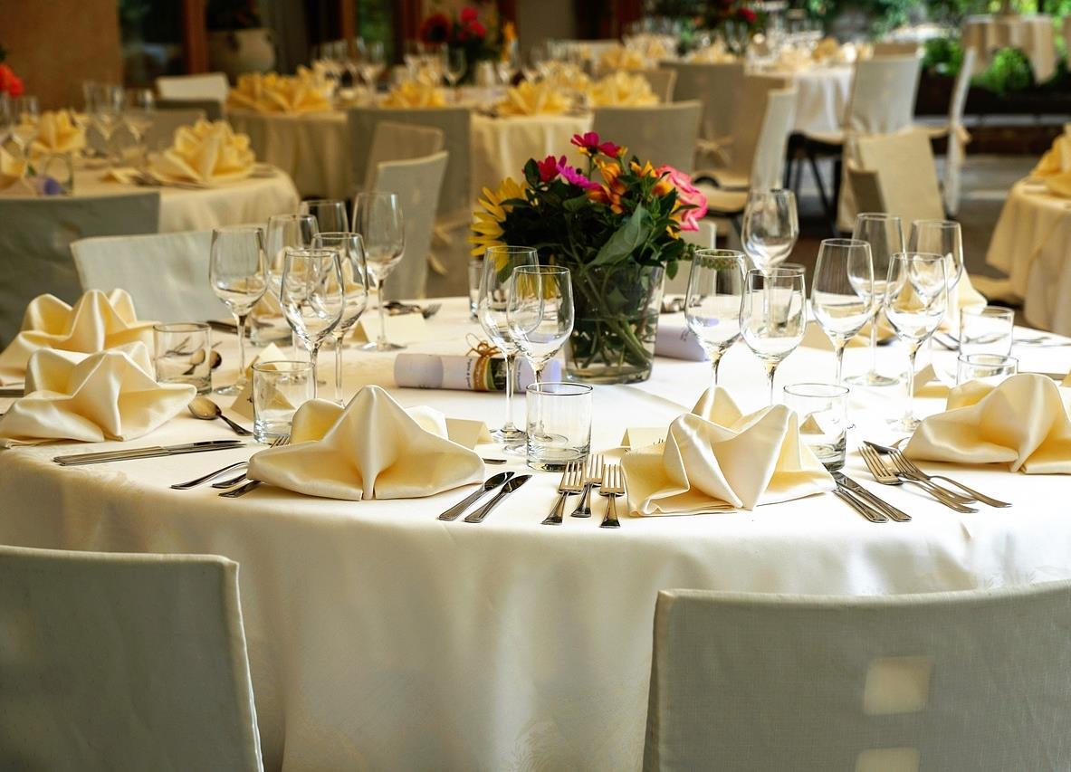 Restaurant med dekkete bord med gule servietter og blomst - Klikk for stort bilde